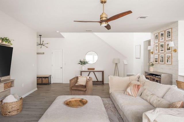 living room featuring baseboards, ceiling fan, visible vents, and wood finished floors