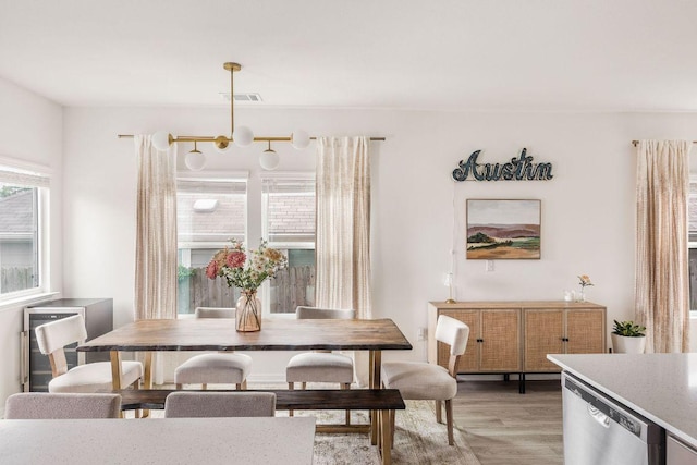 dining room with light wood-style floors and visible vents