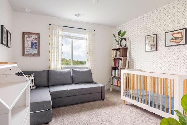 carpeted bedroom with wallpapered walls, visible vents, baseboards, and an accent wall