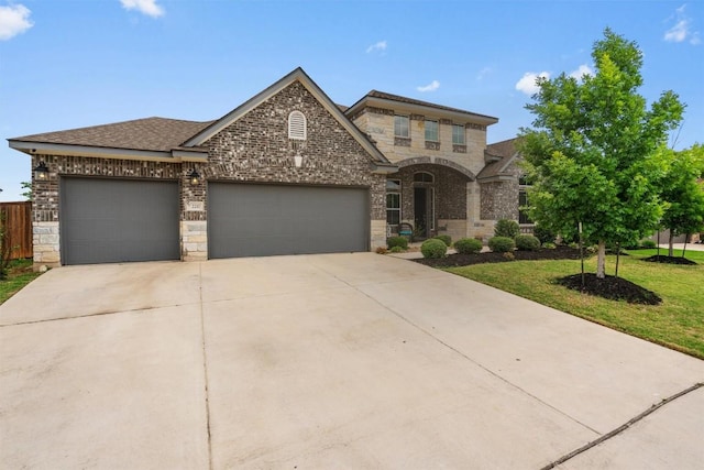 2217 Belen Dr, Leander, TX 78641 - view of front of home featuring driveway, a garage, brick siding, a front lawn, and stone siding