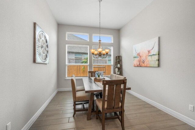 dining room featuring baseboards, a chandelier, and wood finished floors
