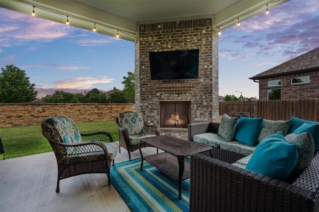 view of patio / terrace featuring fence and an outdoor living space with a fireplace