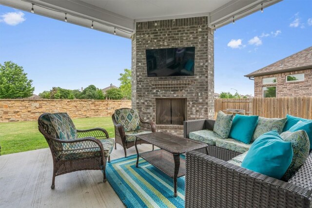 view of patio with fence and an outdoor living space with a fireplace
