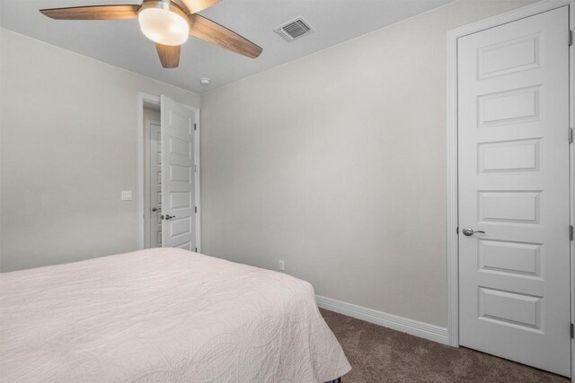 bedroom featuring a ceiling fan, baseboards, visible vents, and dark carpet