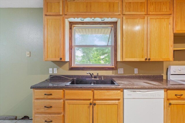 kitchen with a sink, dark countertops, stove, and dishwasher