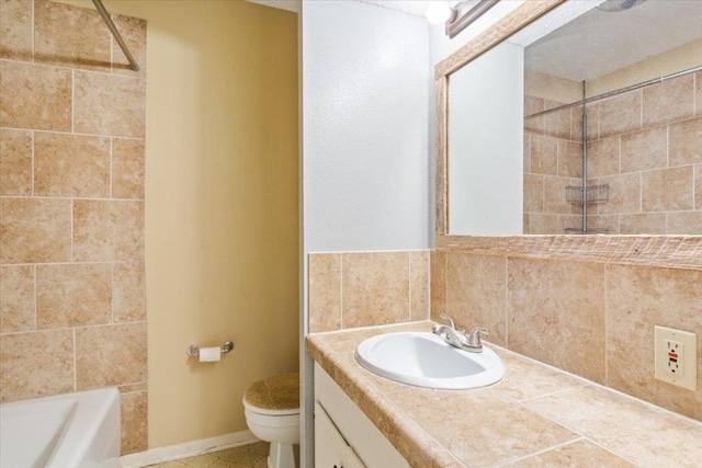 bathroom featuring toilet, decorative backsplash, and vanity