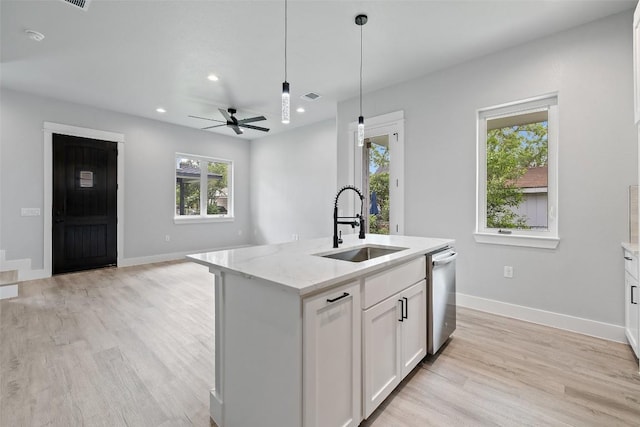 1000B Vargas Rd Unit B, Austin, TX 78741 - kitchen with stainless steel dishwasher, baseboards, white cabinets, a sink, and light wood-style flooring