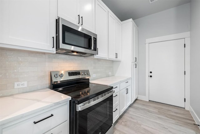 1000B Vargas Rd Unit B, Austin, TX 78741 - kitchen featuring white cabinets, light stone counters, light wood-style flooring, stainless steel appliances, and backsplash