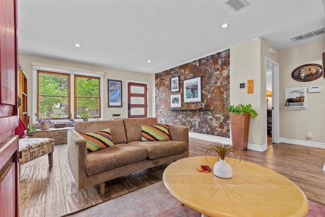 living area featuring visible vents, recessed lighting, baseboards, and wood finished floors