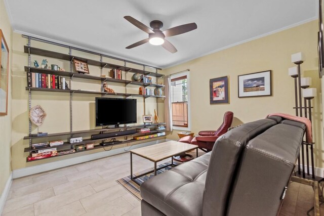 living area featuring ceiling fan, ornamental molding, and baseboards