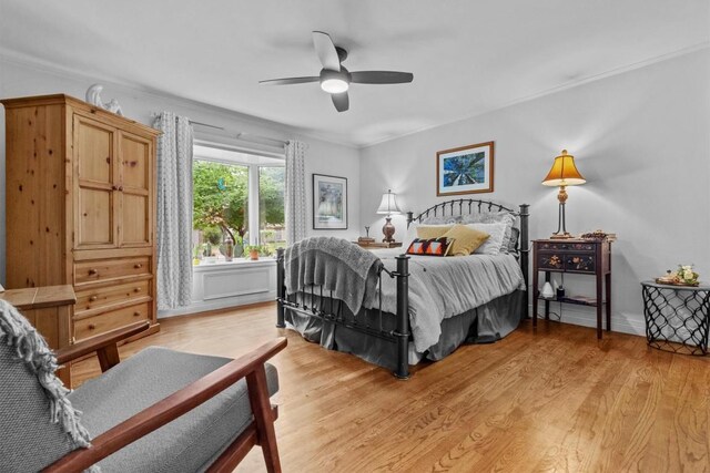 bedroom featuring ceiling fan, ornamental molding, and light wood finished floors