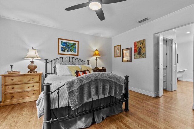 bedroom featuring baseboards, ornamental molding, light wood-style flooring, and visible vents