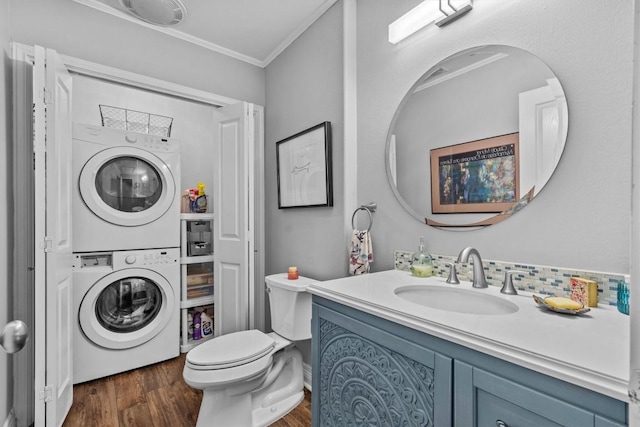 5414 Duval St, Austin, TX 78751 - bathroom featuring stacked washer and clothes dryer, crown molding, vanity, and wood finished floors