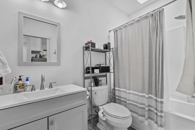 bathroom featuring toilet, shower / bath combo, and vanity