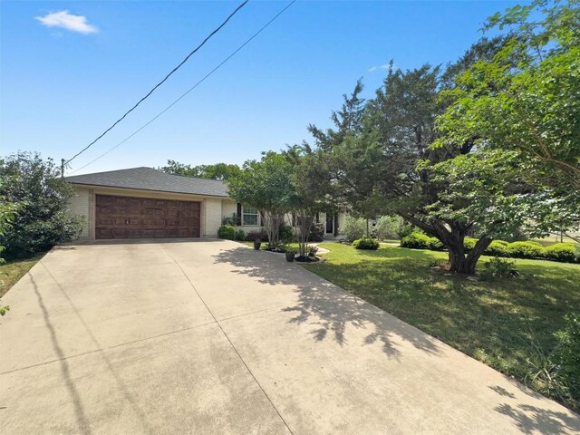 view of front facade with a garage, driveway, and a front yard