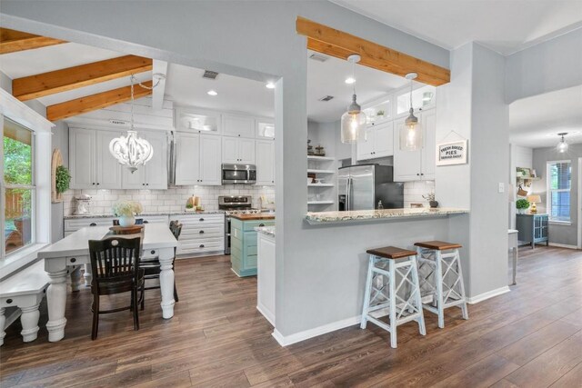 kitchen featuring dark wood-type flooring, backsplash, white cabinets, and stainless steel appliances