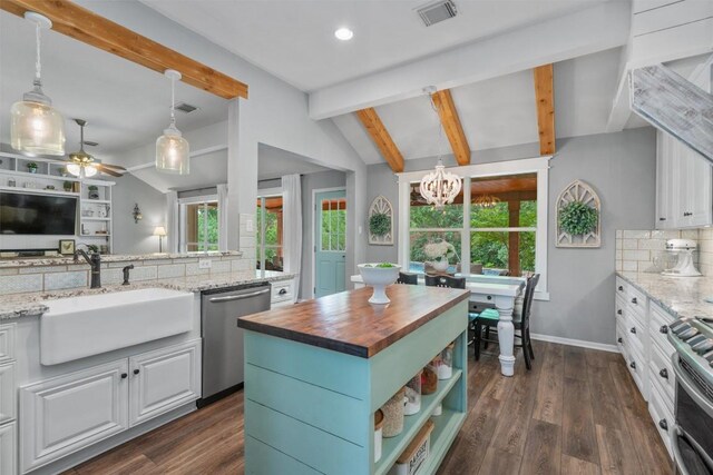 kitchen with appliances with stainless steel finishes, butcher block countertops, vaulted ceiling with beams, tasteful backsplash, and visible vents