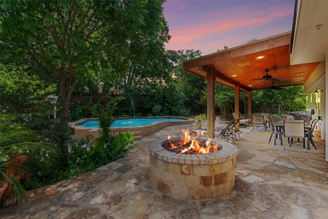 view of patio / terrace with outdoor dining space, an outdoor fire pit, ceiling fan, an outdoor pool, and a fenced backyard