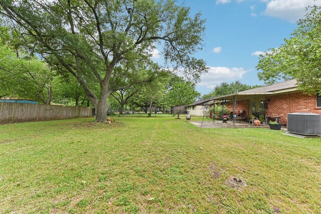 view of yard featuring central AC unit, a patio area, and a fenced backyard