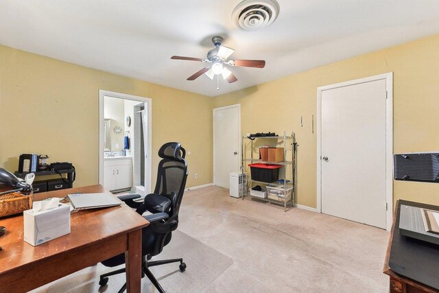office area with visible vents, a ceiling fan, baseboards, and light colored carpet