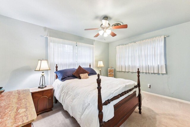 bedroom featuring baseboards, light carpet, and ceiling fan
