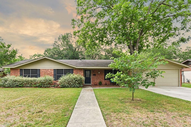 single story home featuring brick siding, driveway, a front yard, and a garage