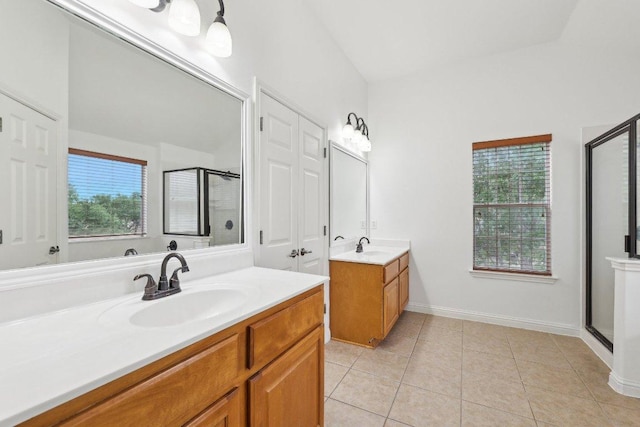 bathroom with tile patterned floors, two vanities, a sink, and a stall shower