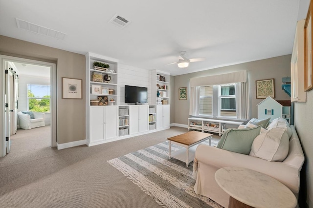 living area with baseboards, light colored carpet, and visible vents