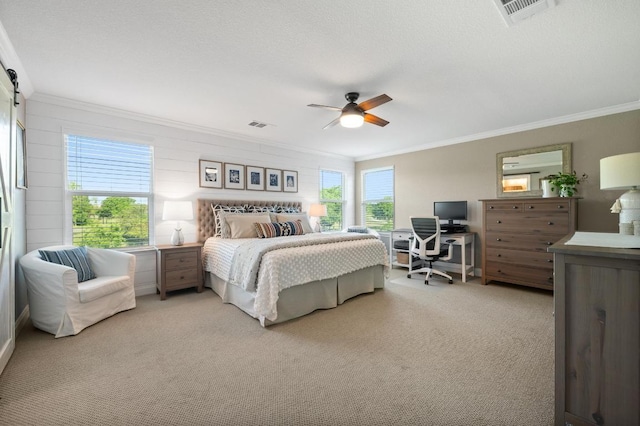 bedroom featuring crown molding, a ceiling fan, visible vents, and light carpet