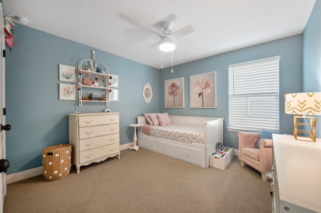 carpeted bedroom featuring baseboards and a ceiling fan