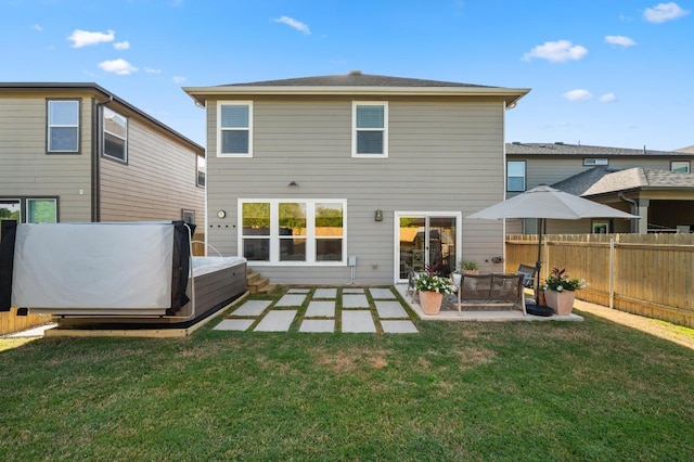 rear view of house featuring a lawn, a patio, and fence