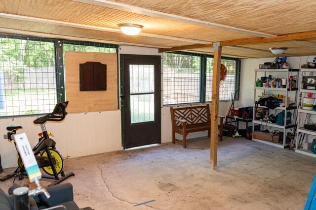 interior space featuring a healthy amount of sunlight, wooden ceiling, and unfinished concrete floors
