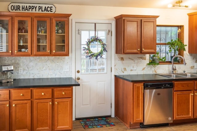 kitchen featuring backsplash, brown cabinets, a sink, and dishwasher