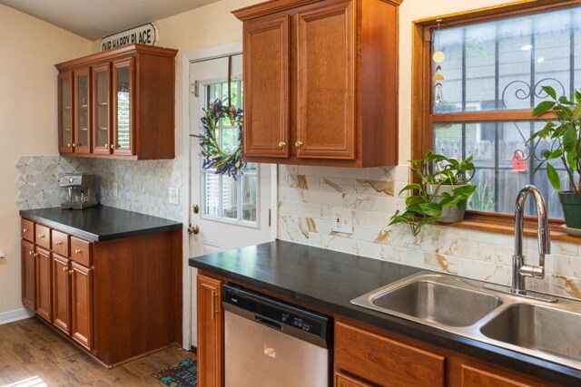 kitchen featuring a sink, dark countertops, a wealth of natural light, and dishwasher