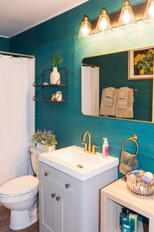full bath featuring crown molding, toilet, curtained shower, and vanity