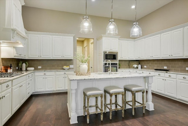 2421 Parisio Ct, Leander, TX 78641 - kitchen with premium range hood, appliances with stainless steel finishes, backsplash, and white cabinetry