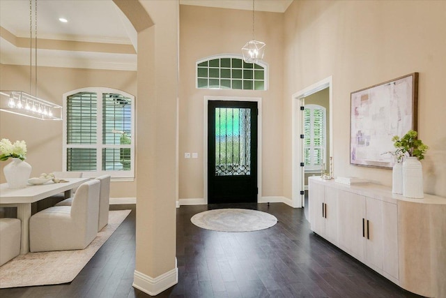 2421 Parisio Ct, Leander, TX 78641 - entryway with dark wood finished floors, ornamental molding, arched walkways, a chandelier, and a towering ceiling