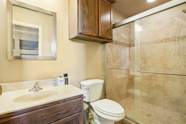 bathroom with vanity, toilet, and a stall shower