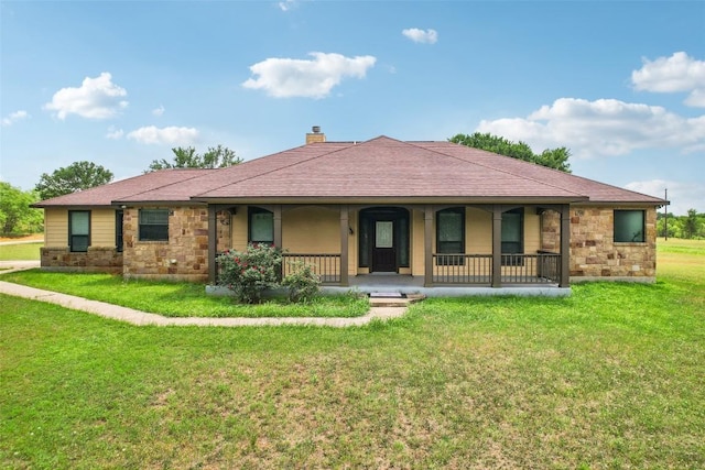 back of property featuring covered porch, a lawn, a chimney, and stone siding