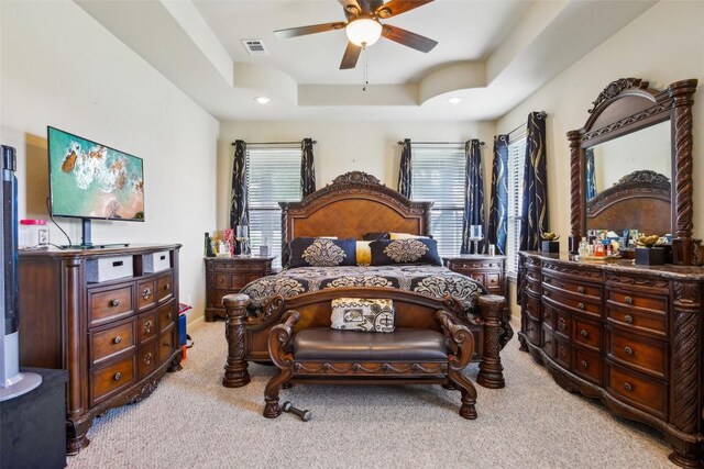 bedroom featuring a raised ceiling, light carpet, recessed lighting, and visible vents