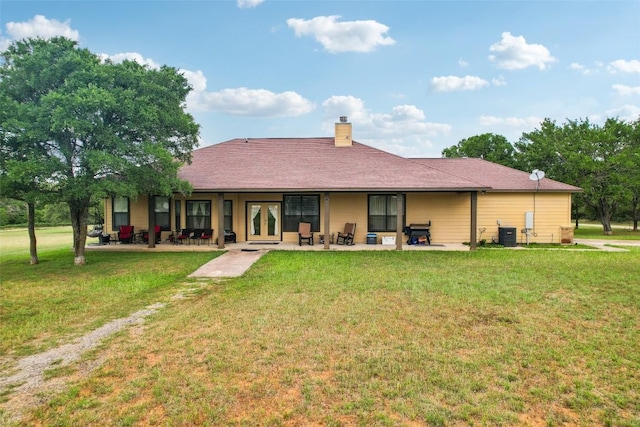 2300 Tumbleweed Trl, Dale, TX 78616 - rear view of house featuring a yard, a chimney, and french doors