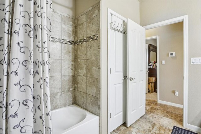 bathroom with baseboards and shower / tub combo