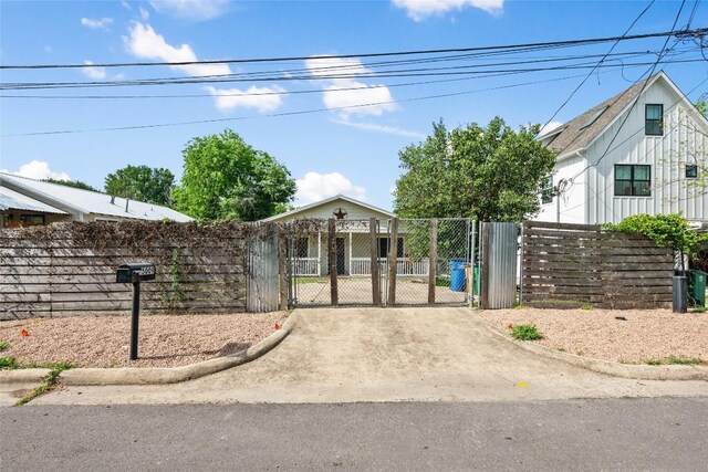 view of front of home featuring a gate, a fenced front yard, and driveway