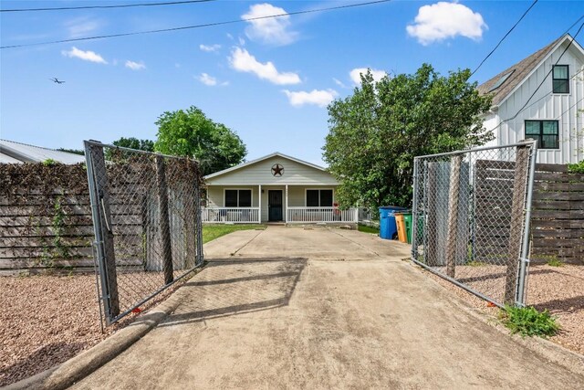 view of gate with fence and a porch