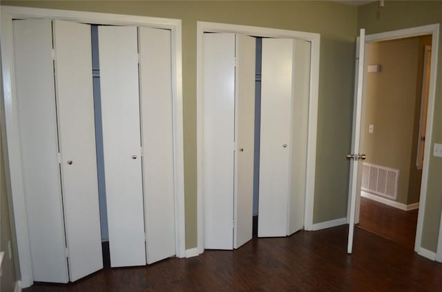 5009 Lott Ave, Austin, TX 78721 - unfurnished bedroom featuring two closets and wood finished floors