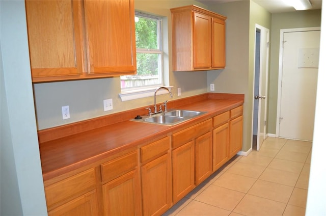 5009 Lott Ave, Austin, TX 78721 - kitchen with a sink, light tile patterned floors, and baseboards