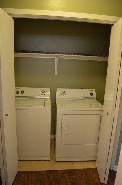 laundry area featuring laundry area, light tile patterned floors, and washing machine and dryer