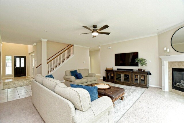 tiled living area featuring baseboards, ornamental molding, ceiling fan, and stairway