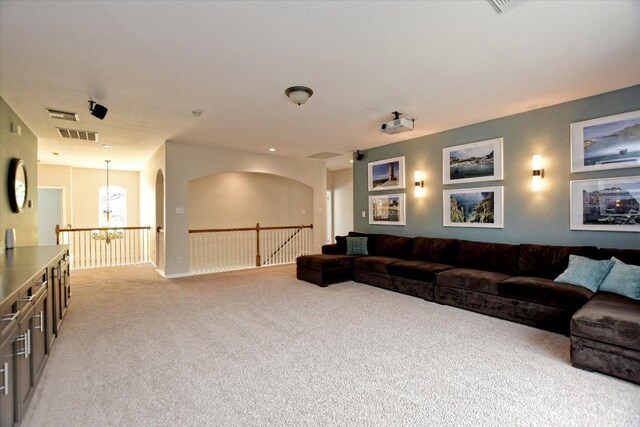 living area featuring a chandelier, light colored carpet, and visible vents