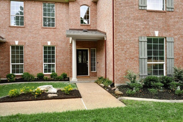 doorway to property featuring brick siding